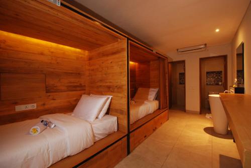 库塔DBeds Kuta Beach By Destiny Hospitality的一间带两张木墙床的卧室