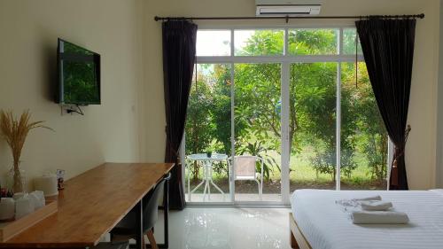 班巴克洛普吉岛贪睡旅店的一间卧室配有一张床、一张书桌和一个大窗户