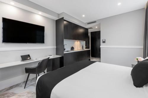 悉尼Holiday Inn & Suites - Parramatta Marsden Street, an IHG Hotel的一间卧室配有一张床,墙上配有电视