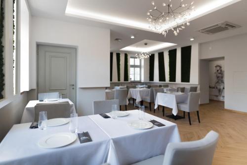 肯普诺Kempen的餐厅配有白色的桌椅和吊灯