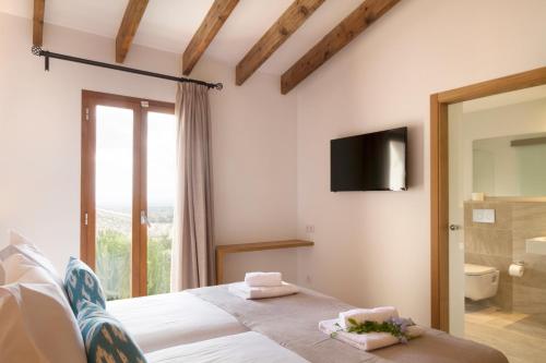 塞尔瓦Angels Boutique - Turismo de interior的卧室配有一张床,墙上配有电视。