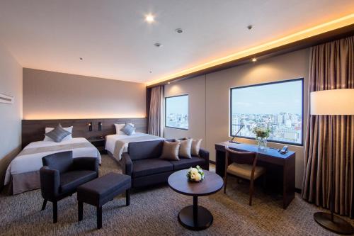 川崎川崎日航酒店的酒店客房,设有两张床和一张沙发