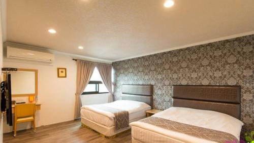 宜兰市快乐几迷会馆的酒店客房配有两张床和一张书桌