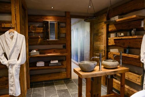夏蒙尼-勃朗峰Chalets Grands Montets的浴室设有木墙和两个水槽。