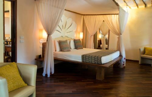 南威Essque Zalu Zanzibar的一间卧室配有床、窗帘和沙发