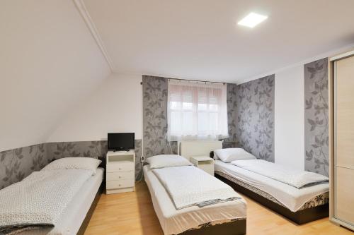 布达佩斯米可夫高朵酒店的一间卧室设有三张床和窗户。
