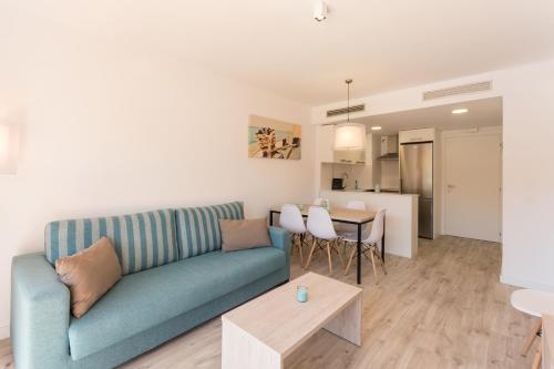 埃斯塔蒂特埃斯塔蒂特海滩皮埃里公寓的客厅配有蓝色的沙发和桌子