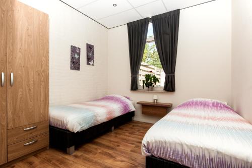 凯瑟尔瓦坎提图姆可露营旅馆的一间卧室设有两张床和窗户。