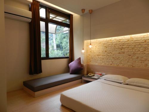 和平区谷關明高溫泉 Mingao Hot Spring Resort的一间卧室设有一张床和一个带长凳的窗户