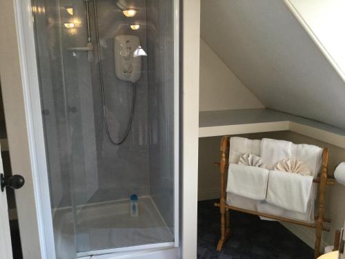 因弗内斯Three-Bedroom Old Cottage Free Parking的一间带淋浴的浴室和位于阁楼的椅子