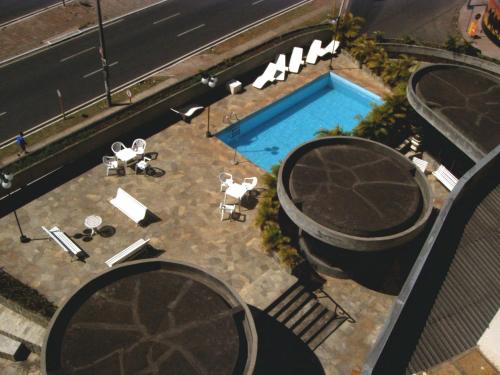 巴乌鲁Obeid Plaza Hotel的享有带桌椅的游泳池的顶部景致