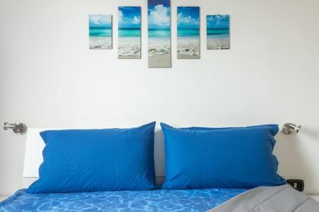 Milis意大利住宿加早餐旅馆的卧室内的一张带蓝色枕头的床
