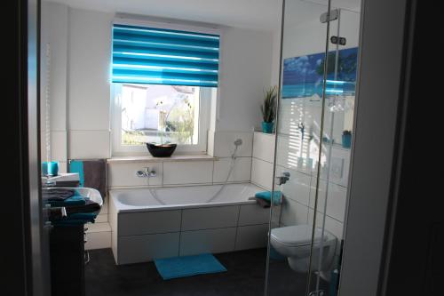 莱比锡Villa LE的带浴缸、卫生间和窗户的浴室