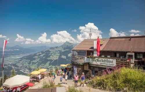 基茨比厄尔Hocheckhuette On Top of the Kitzbuehel Hahnenkamm Mountain的一群站在建筑物前的人