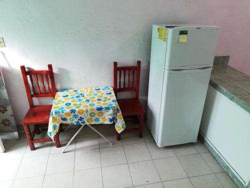 莱昂Habitaciones amuebladas. Poliforum/Centro的厨房配有桌子、两把椅子和冰箱