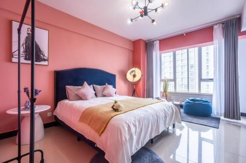 郑州郑州市金水区·省政府·路客精品公寓·00161830的卧室配有一张带粉红色墙壁的大床