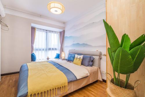 郑州郑州市中原区·中原万达广场·路客精品公寓·00159010的一间卧室配有一张床和盆栽植物