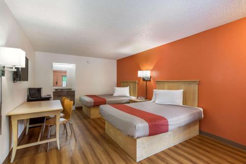 MacclennyMotel 6-Macclenny, FL的酒店客房配有两张床、一张书桌和一张书桌。