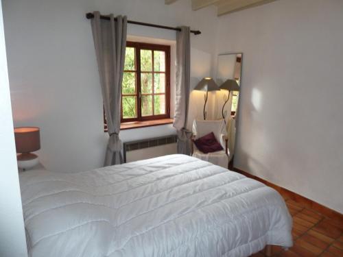 PinetGITE "LES GILLES" ET SES ANIMAUX CALME-BON AIR - 5 personnes的卧室配有白色的床和窗户。