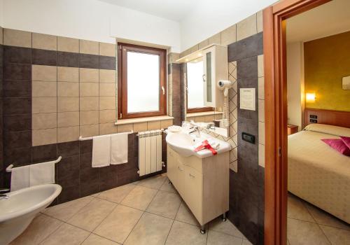 Mozzagrogna伊甸园公寓式酒店的一间带水槽和床的浴室