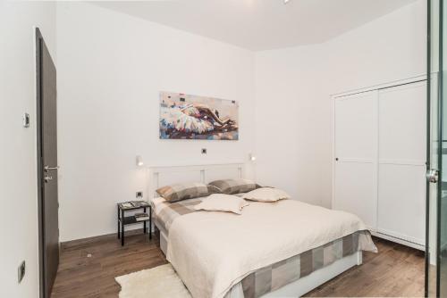 里耶卡Apartment Mille的卧室配有一张床,墙上挂有绘画作品