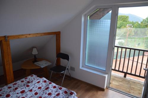 肯普隆格Baza Sportiva Adelina的一间卧室配有一张床、一张书桌和一个窗户。