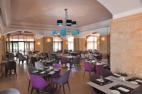 库克里亚Atlantica Aphrodite Hills Hotel的一间带桌子和紫色椅子的用餐室