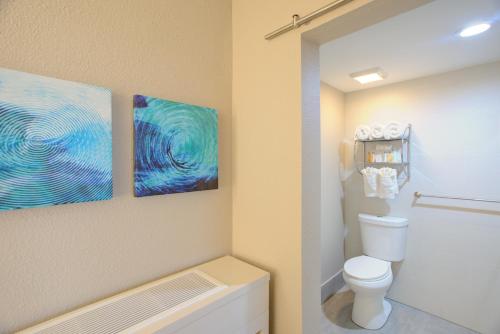 杰基尔岛比奇维尤俱乐部酒店的一间带卫生间的浴室和墙上的两幅画作