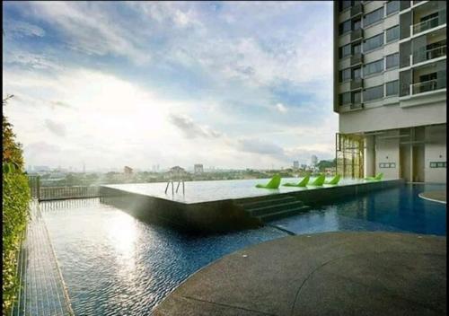 吉隆坡Luxury Resort Suite Kuala Lumpur@5mins to Mid Valley, Sunway的一座建筑物旁边,有水池