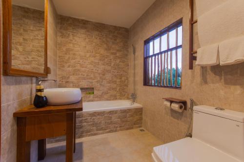 乌库拉斯西沙滩旅馆的浴室配有盥洗盆和浴缸。