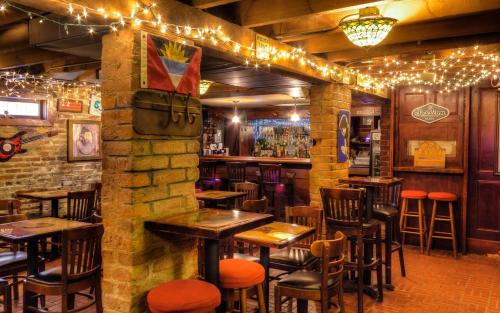 奥古斯塔Olde Town Inn的酒吧配有木桌和椅子及灯