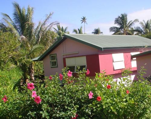 飞鱼湾木槿之家旅馆的前面有鲜花的粉红色房子