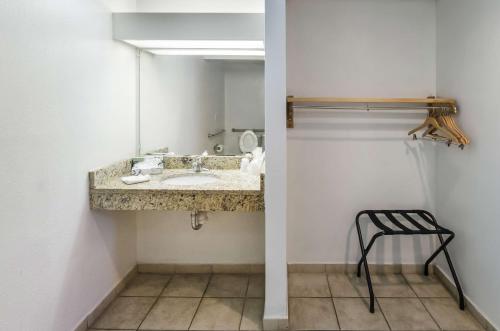 萨凡纳Motel 6-Pooler, GA - Savannah Airport的一间带水槽、镜子和凳子的浴室
