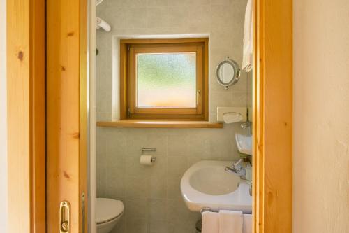塞尔瓦迪加尔代纳山谷Villa Insam的一间带水槽和卫生间的浴室以及窗户。