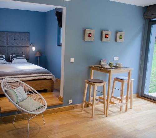 斯帕La Suite Des Pervenches的一间卧室配有一张床、两把椅子和一张桌子