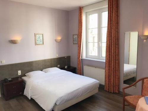 布兰肯贝赫克拉里奇酒店的卧室设有一张白色大床和一扇窗户。