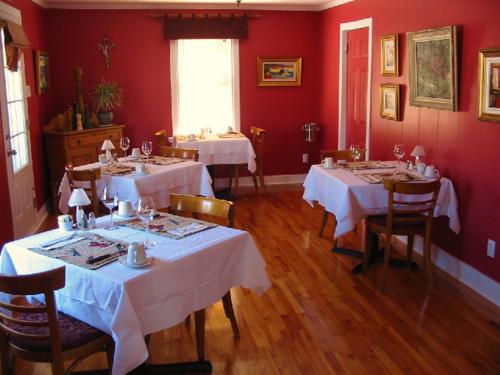 Godbout理查德艾尔住宿加早餐旅馆的一间用餐室,配有2张带白色桌布的桌子