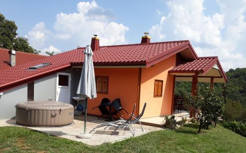 圣马丁娜穆里Kuća za odmor "Nedeljko"/ Holliday hause "Nedeljko"的一座带雨伞和桌椅的小房子