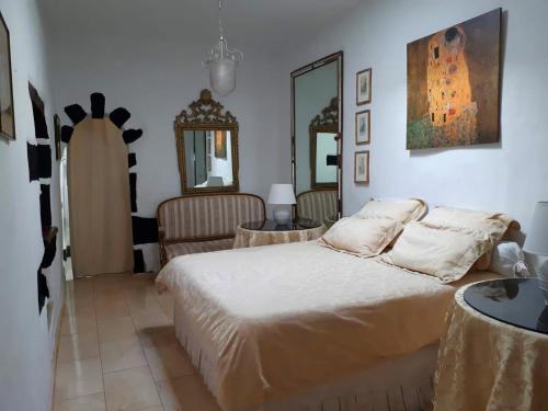 马赫Casa Tara的一间卧室配有一张床、两把椅子和镜子