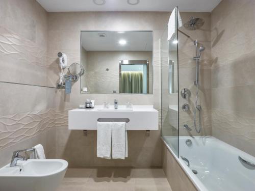 隆达梅斯特拉萨酒店的浴室配有盥洗盆、镜子和浴缸