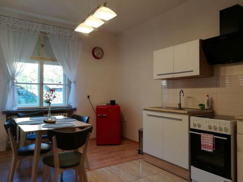 克雷姆尼察Apartmán s výhľadom的厨房配有桌子和红色冰箱
