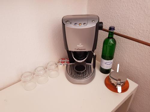 鲁多尔施塔特Casa Conne的咖啡壶和柜台上的一瓶葡萄酒