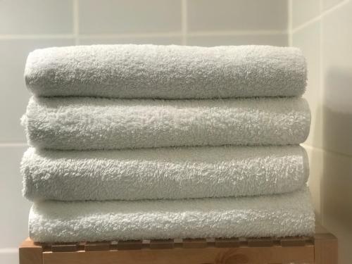 圣加尔米耶Maison Ladeveze的四条毛巾在浴室内堆叠在一起