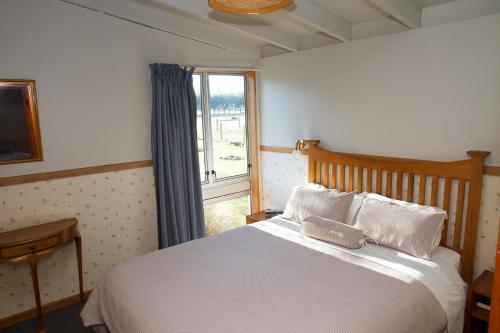 Mount SomersStronechrubie Accommodation and Restaurant的卧室配有白色的床和窗户。