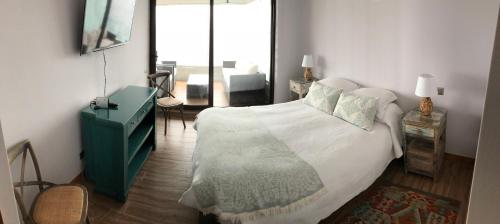 普孔Depto. orilla de lago Villarrica的一间卧室配有一张大床和绿色梳妆台