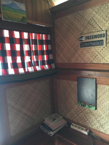 ManinjauEka's Bungalows的架子上挂着旗帜和电话的房间