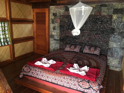 ManinjauEka's Bungalows的一间卧室配有带毛巾的床