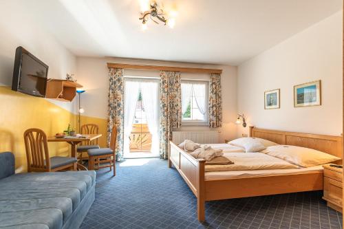 伊布斯河畔格施特灵Hotel - Pension Scheiblechner的一间卧室配有一张床、一张桌子和一张桌子
