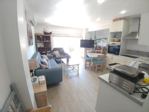 阿尔姆尼卡Apartamento Caléndula的厨房以及带蓝色沙发的起居室。