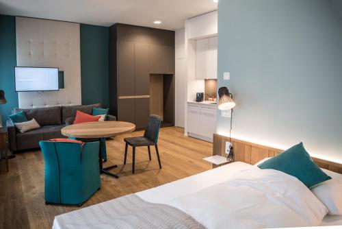 AlberswilAparthotel Luzern West的酒店客房配有床、桌子和沙发。
